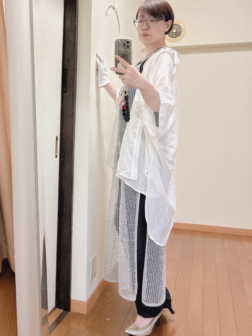 ブラック系のスラックス、シルバー系のワンピース、ホワイト系のシャツ/ブラウスを着用したレディースの夏コーディネートの2枚目の写真