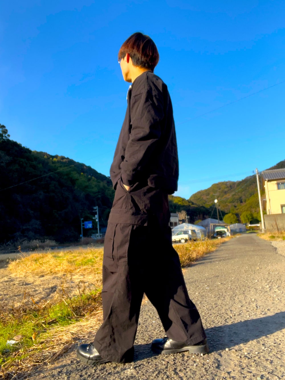 レッド系のニット/セーター、ブラック系のTシャツ/カットソー、ブラック系のカーゴパンツを着用したメンズの冬コーディネートの2枚目の写真