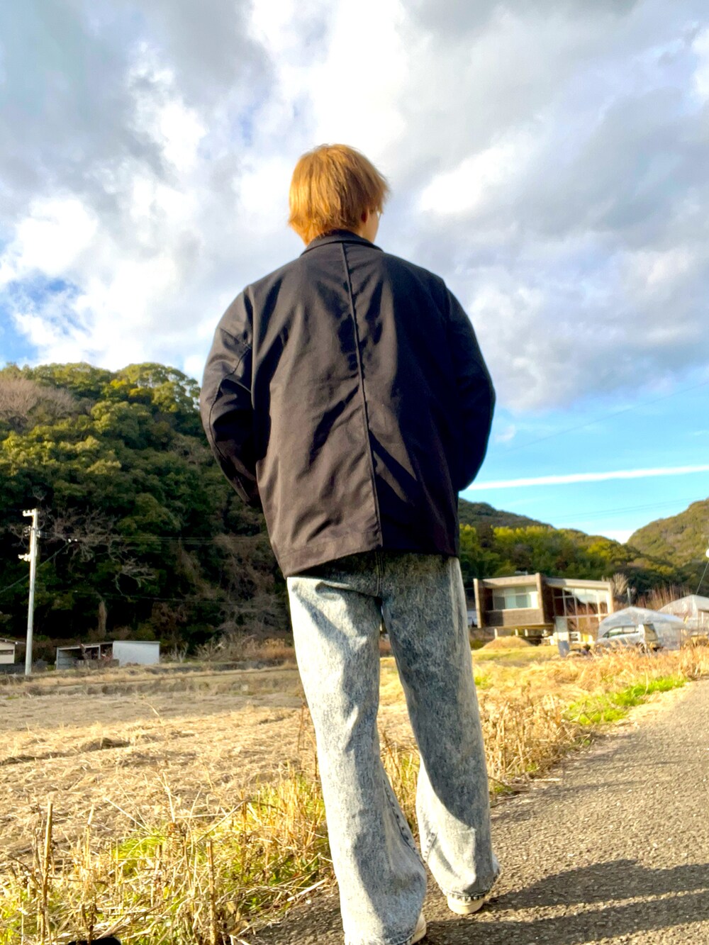 ブラック系のブルゾン、ホワイト系のスウェット、ブルー系のデニムパンツを着用したメンズの冬コーディネートの4枚目の写真