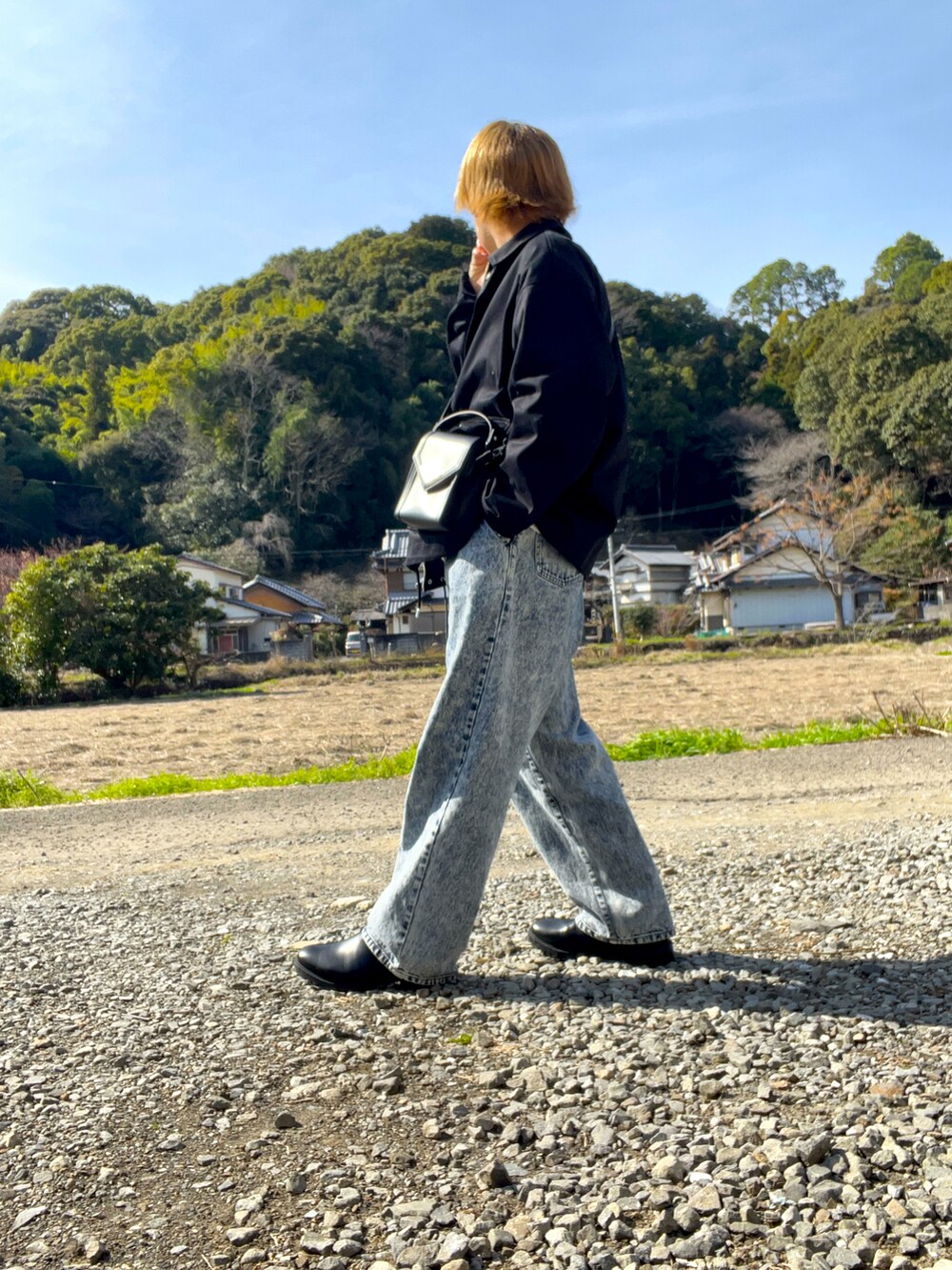 ブラック系のブルゾン、ホワイト系のスウェット、ブルー系のデニムパンツを着用したメンズの冬コーディネートの4枚目の写真