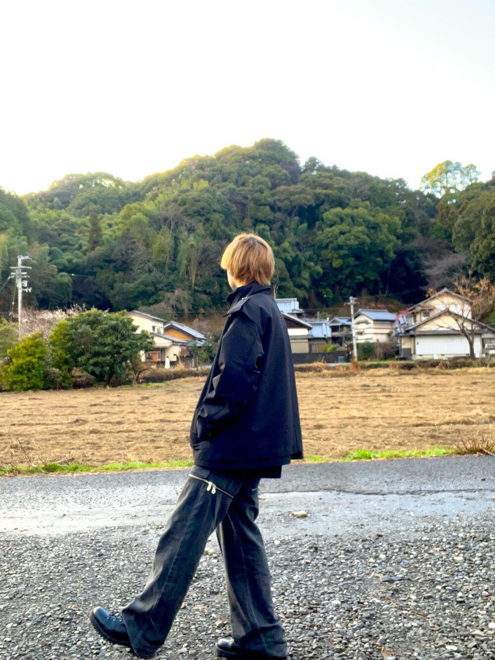 ブラック系のトレンチコート、グレー系のデニムパンツ、レッド系のニット/セーターを着用したメンズの冬コーディネートの2枚目の写真