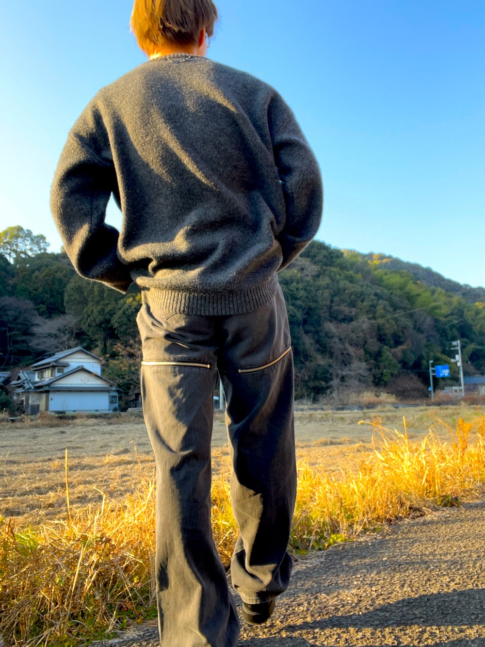 ブラック系のニット/セーター、グレー系のデニムパンツ、ブラック系のブーツを着用したメンズの冬コーディネートの3枚目の写真