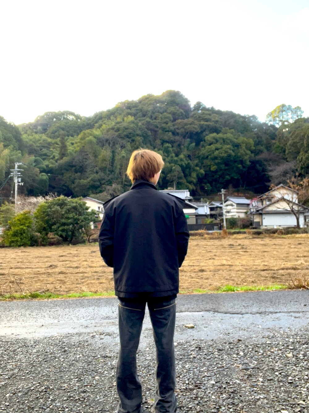 ブラック系のトレンチコート、グレー系のデニムパンツ、レッド系のニット/セーターを着用したメンズの冬コーディネートの3枚目の写真