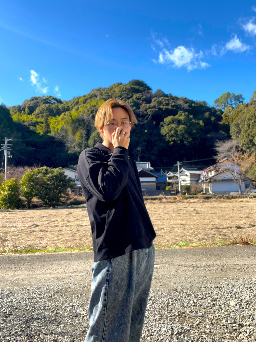 ブラック系のニット/セーター、ブラック系のTシャツ/カットソー、ブルー系のデニムパンツを着用したメンズの冬コーディネートの2枚目の写真