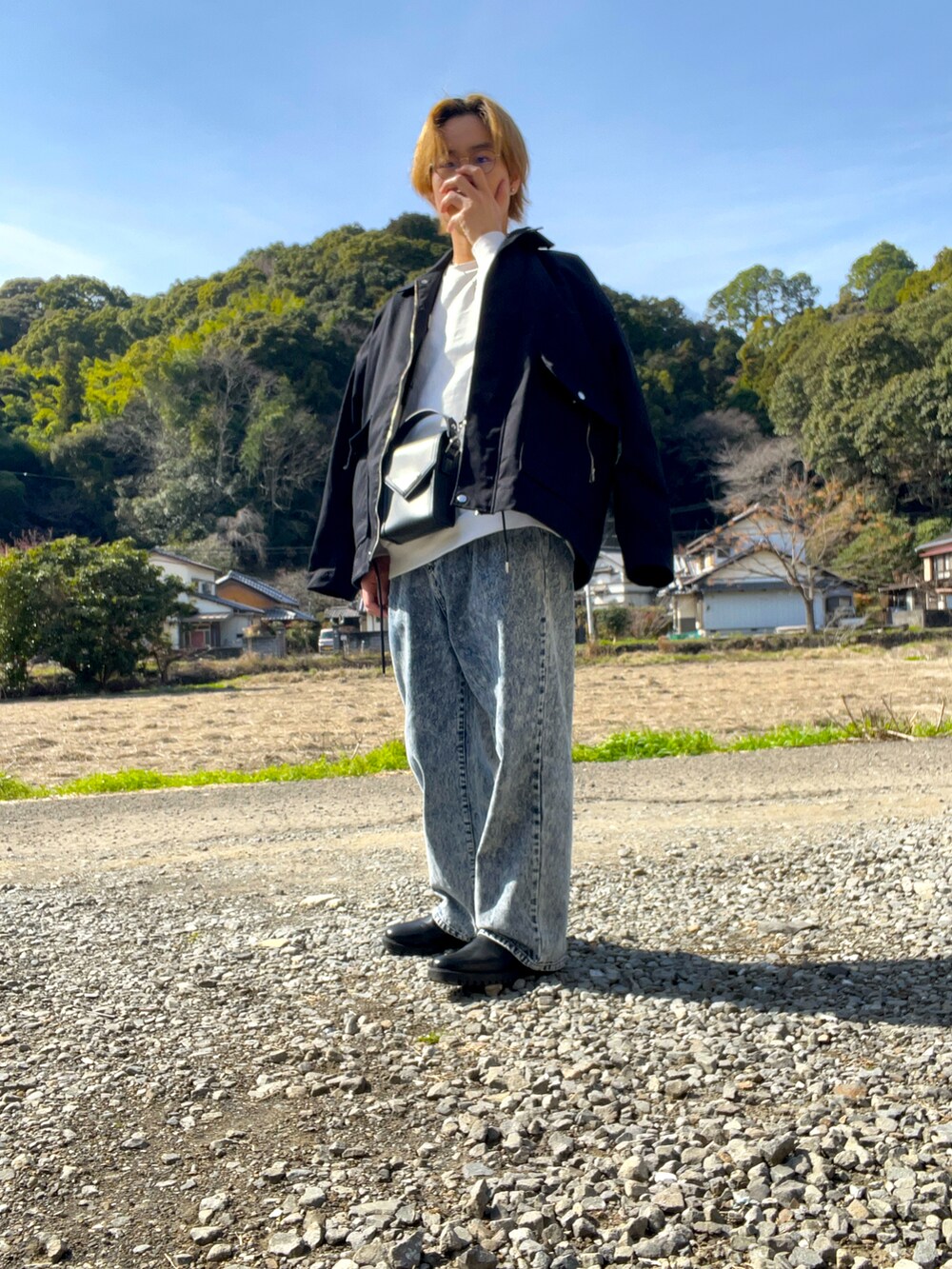 ブラック系のブルゾン、ホワイト系のスウェット、ブルー系のデニムパンツを着用したメンズの冬コーディネートの3枚目の写真