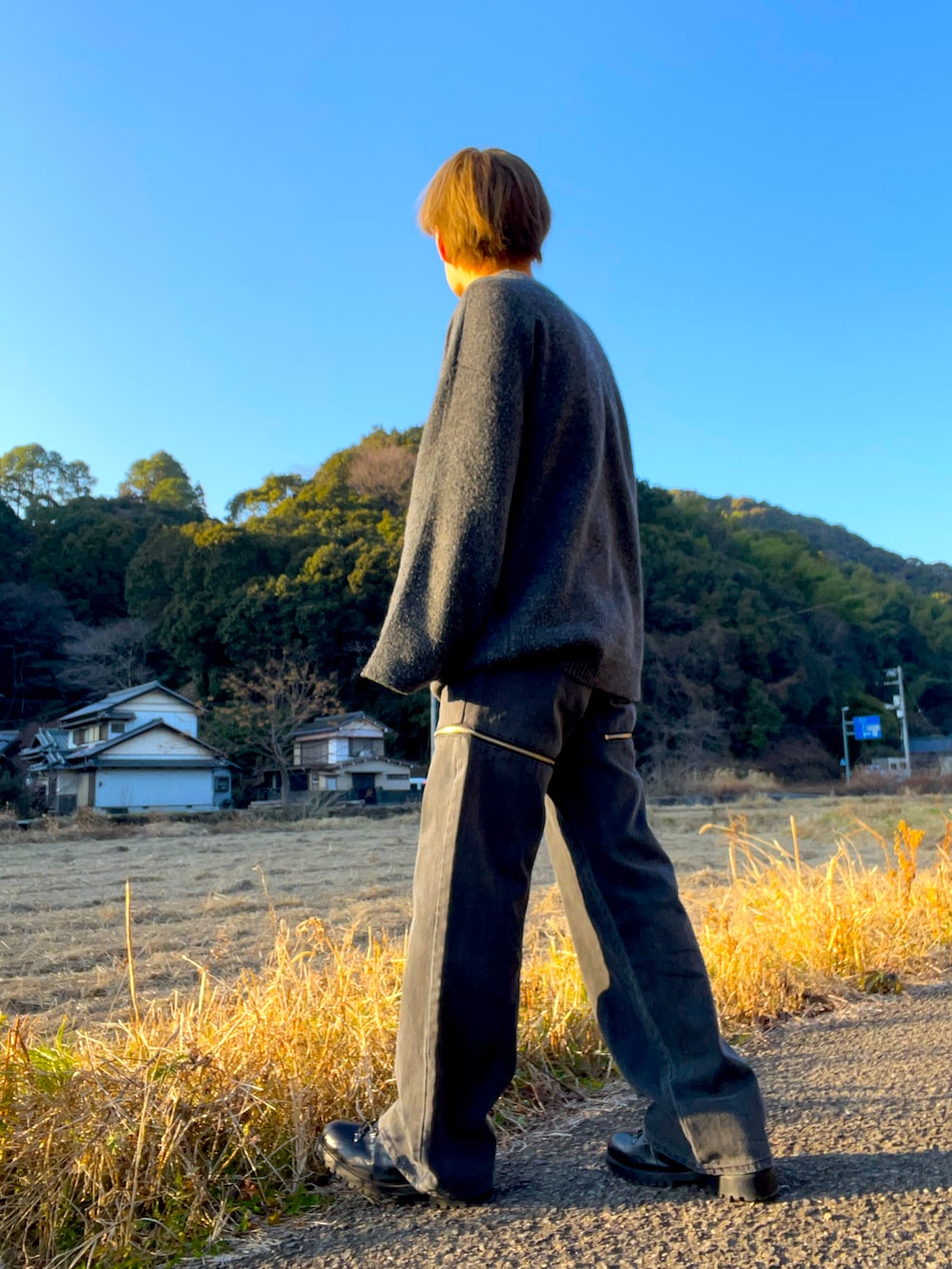 ブラック系のニット/セーター、グレー系のデニムパンツ、ブラック系のブーツを着用したメンズの冬コーディネートの2枚目の写真