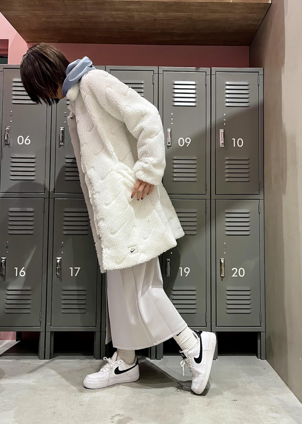 ホワイト系のその他アウター、ホワイト系のスニーカー、グレー系のスカートを着用したレディースの冬コーディネートの2枚目の写真