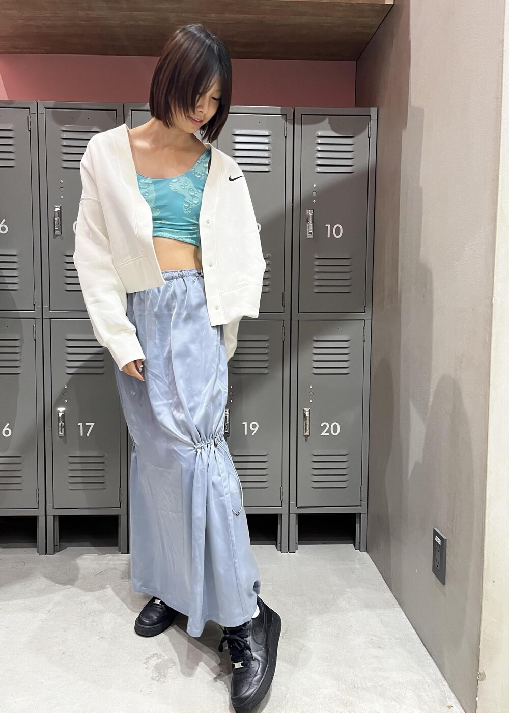 ブラック系のスニーカー、ホワイト系のカーディガン/ボレロ、シルバー系のワンピースを着用したレディースの冬コーディネートの3枚目の写真