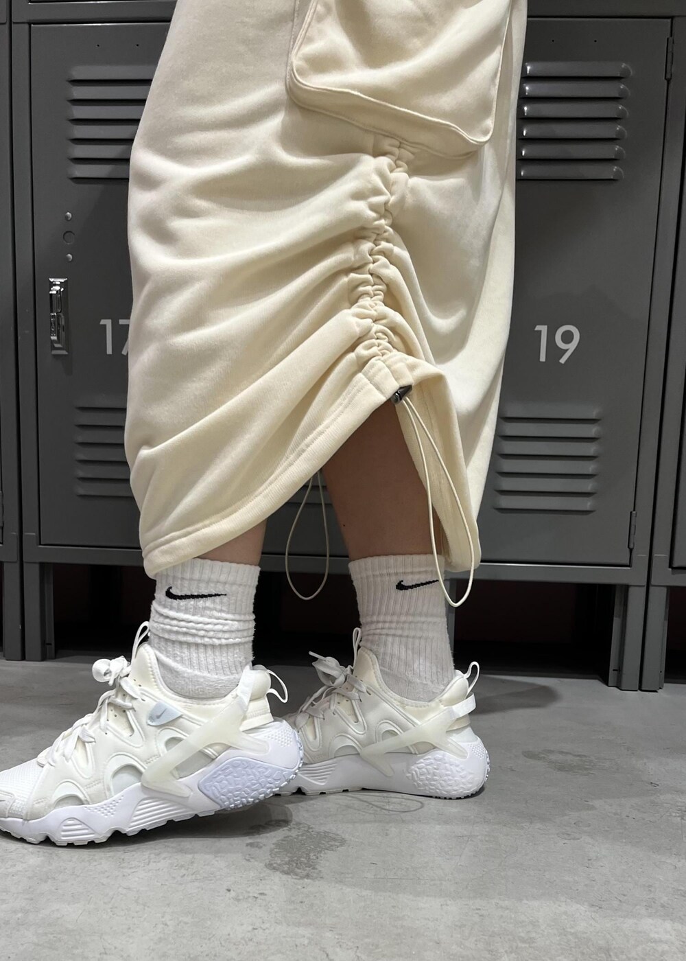 ブラック系のその他アウター、ホワイト系のスカート、ホワイト系のパーカーを着用したレディースの冬コーディネートの6枚目の写真