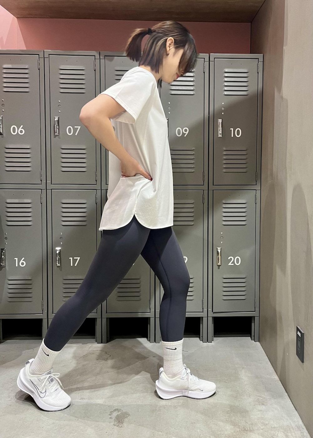 ホワイト系のTシャツ/カットソー、ホワイト系のスニーカー、グレー系のレギンス/スパッツを着用したレディースの冬コーディネートの2枚目の写真