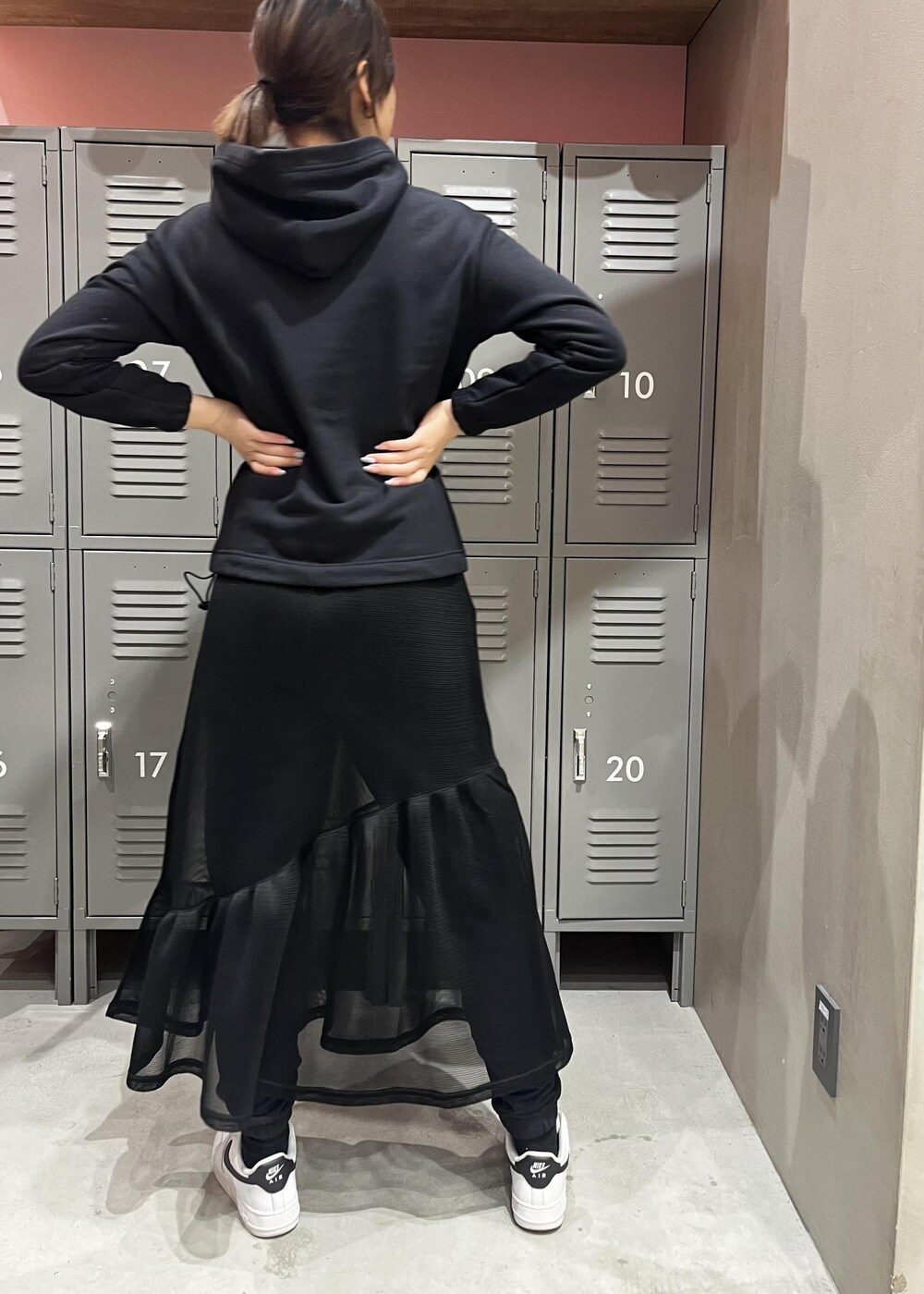 ホワイト系のスニーカー、ブラック系のパーカー、ブラック系のその他パンツを着用したレディースの冬コーディネートの2枚目の写真