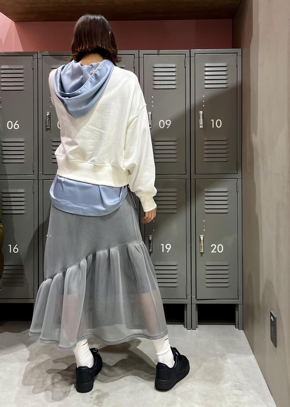 シルバー系のモッズコート、グレー系のスカート、ホワイト系のスウェットを着用したレディースの冬コーディネートの2枚目の写真