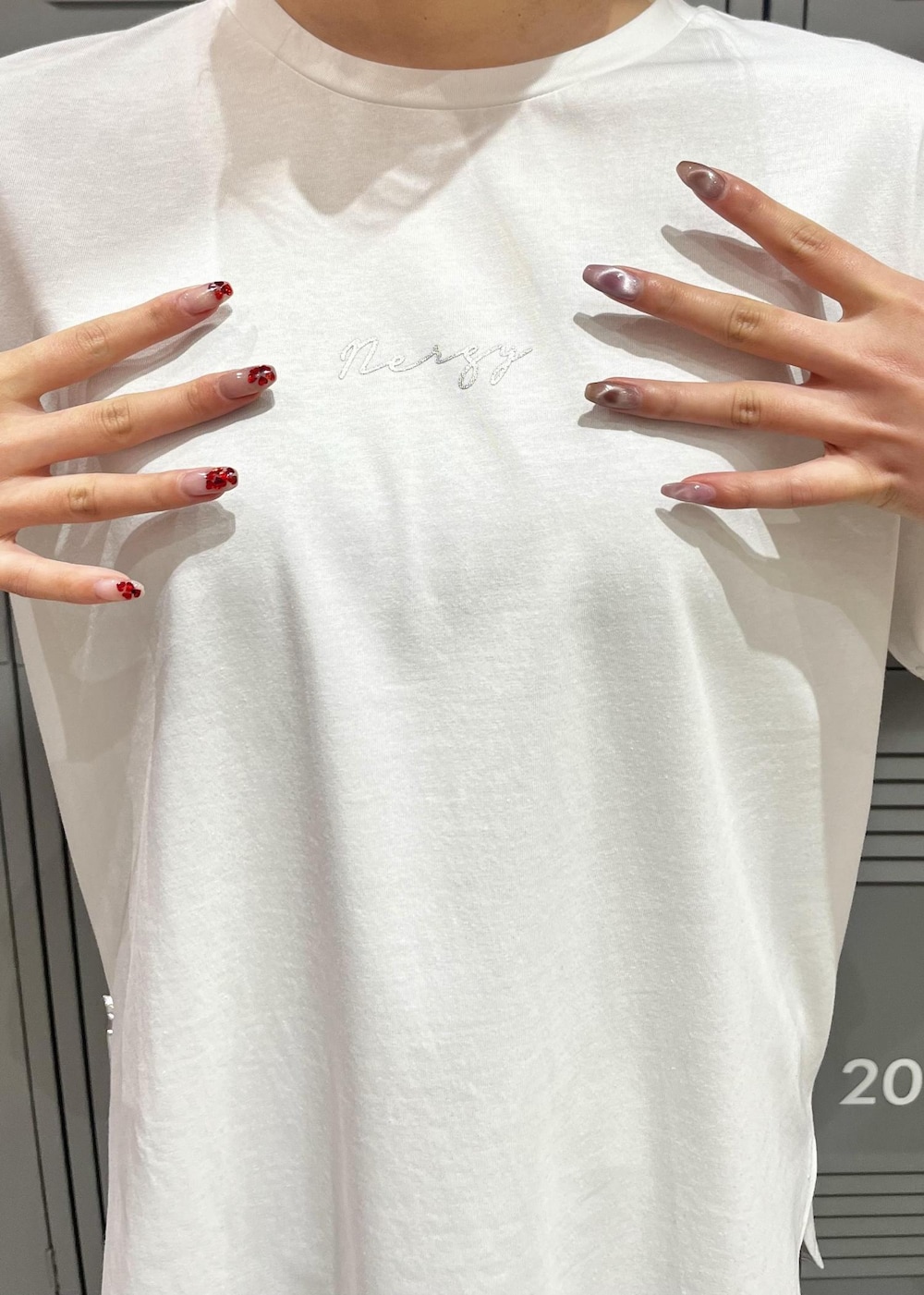 ホワイト系のTシャツ/カットソー、ホワイト系のスニーカー、グレー系のレギンス/スパッツを着用したレディースの冬コーディネートの4枚目の写真