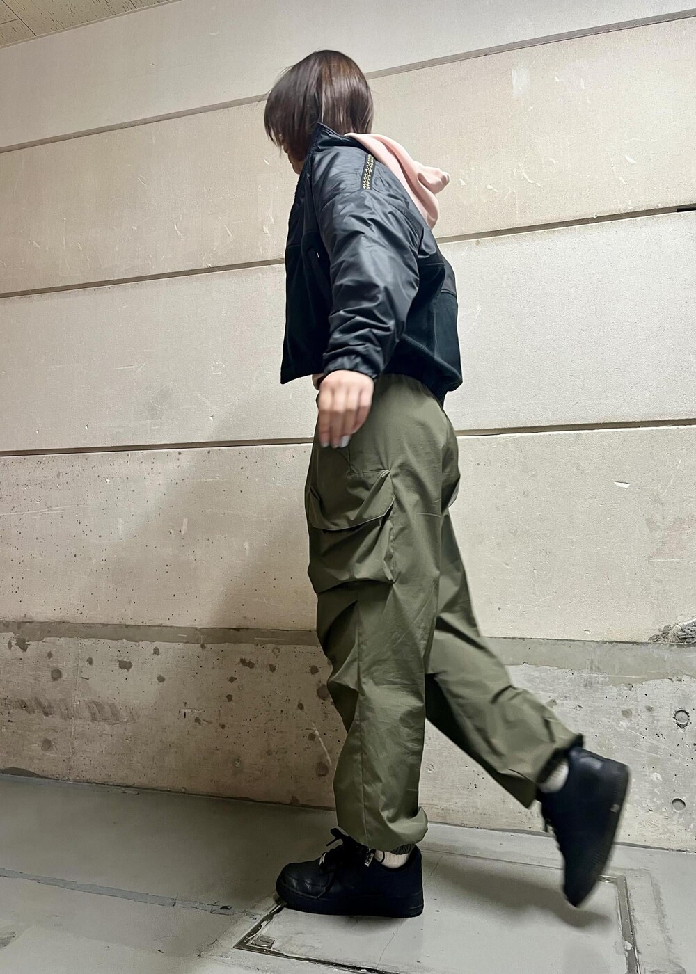 ブラック系のスニーカー、グリーン系のその他パンツ、ブラック系のその他アウターを着用したレディースの冬コーディネートの2枚目の写真