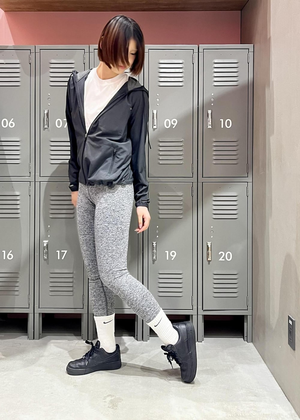 ブラック系のスニーカー、ブラック系のマウンテンパーカー、ホワイト系のTシャツ/カットソーを着用したレディースの春コーディネートの4枚目の写真