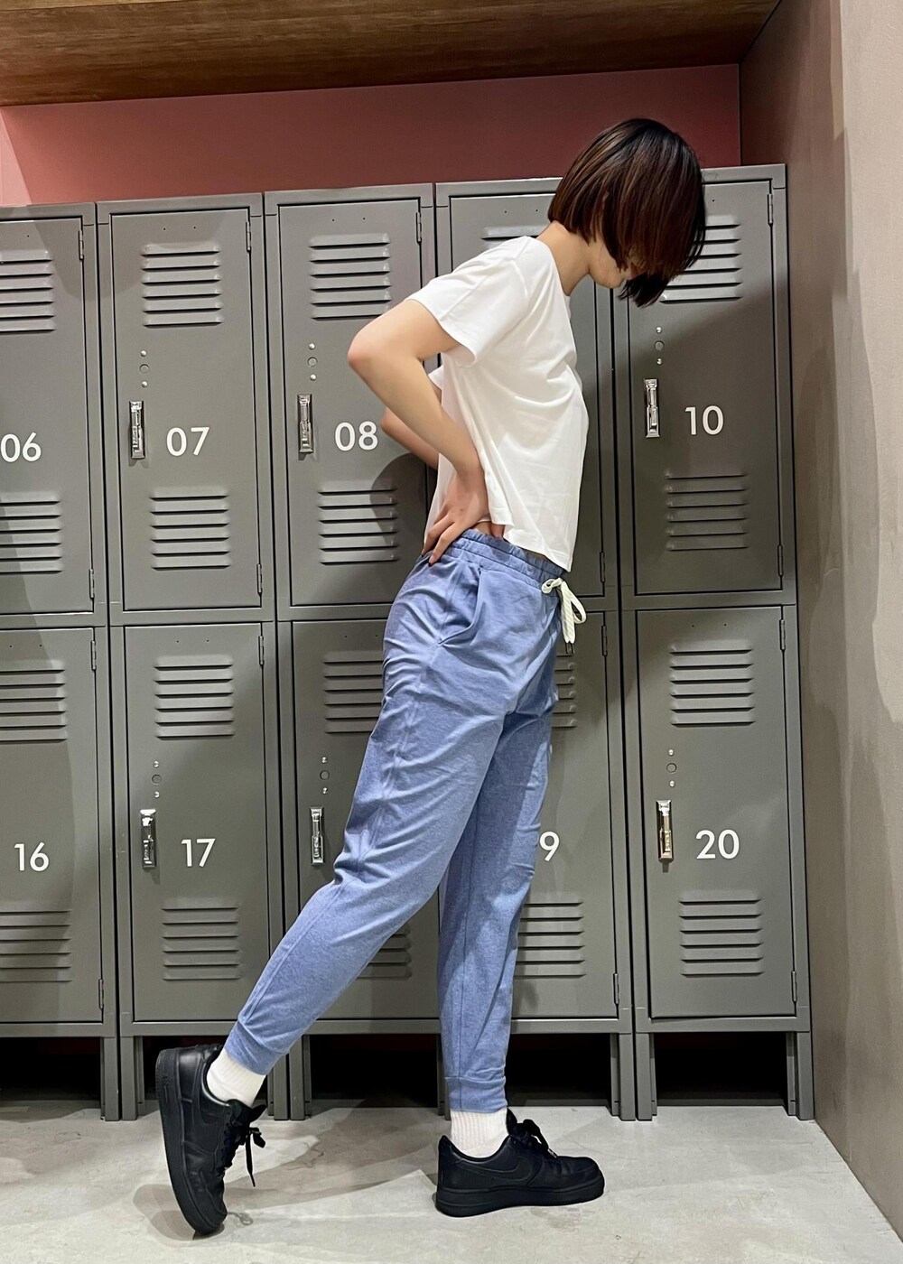 ブラック系のスニーカー、ホワイト系のTシャツ/カットソー、ブルー系のレギンス/スパッツを着用したレディースの春コーディネートの2枚目の写真