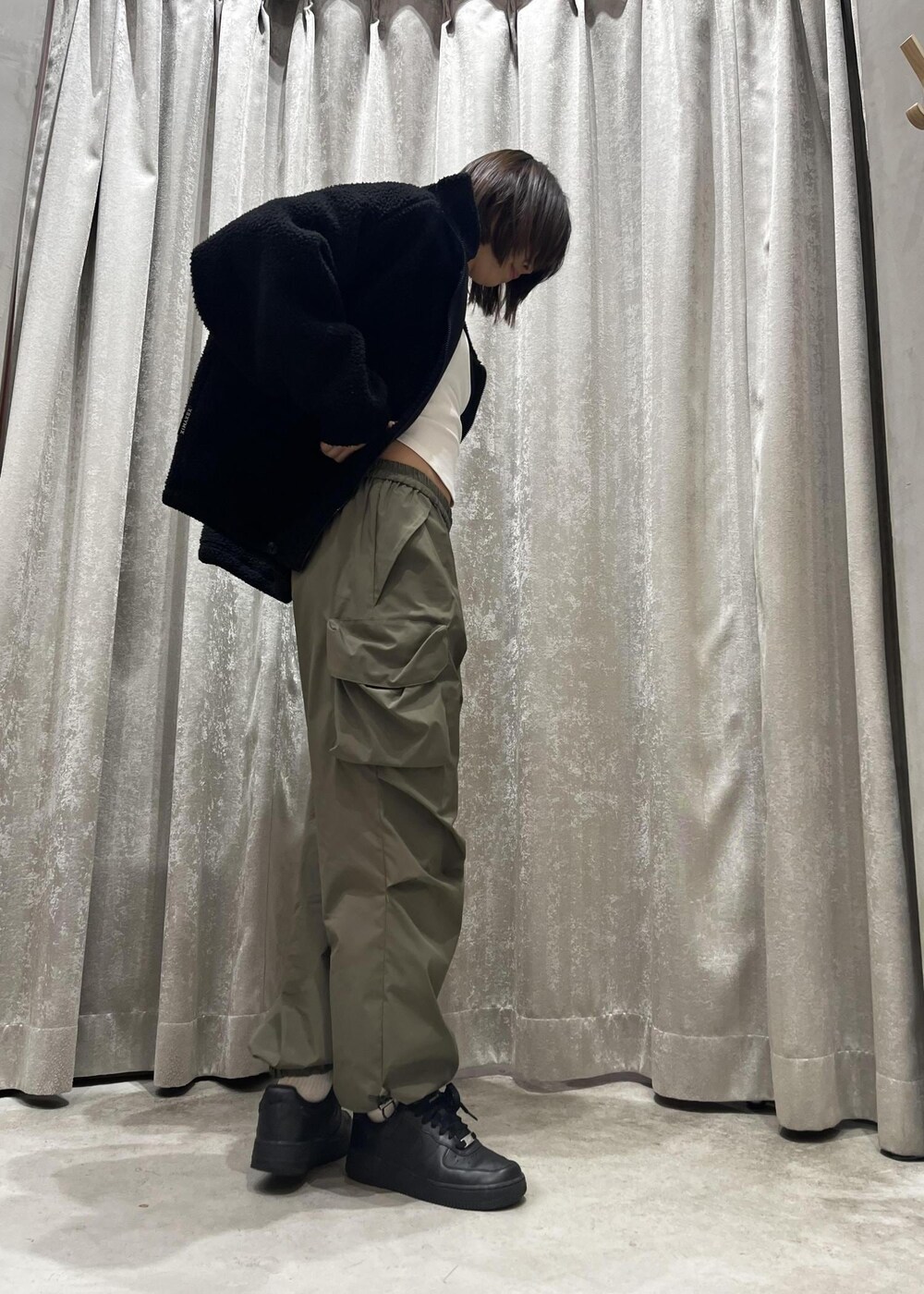 ブラック系のスニーカー、グリーン系のその他パンツ、ブラック系のその他アウターを着用したレディースの冬コーディネートの3枚目の写真