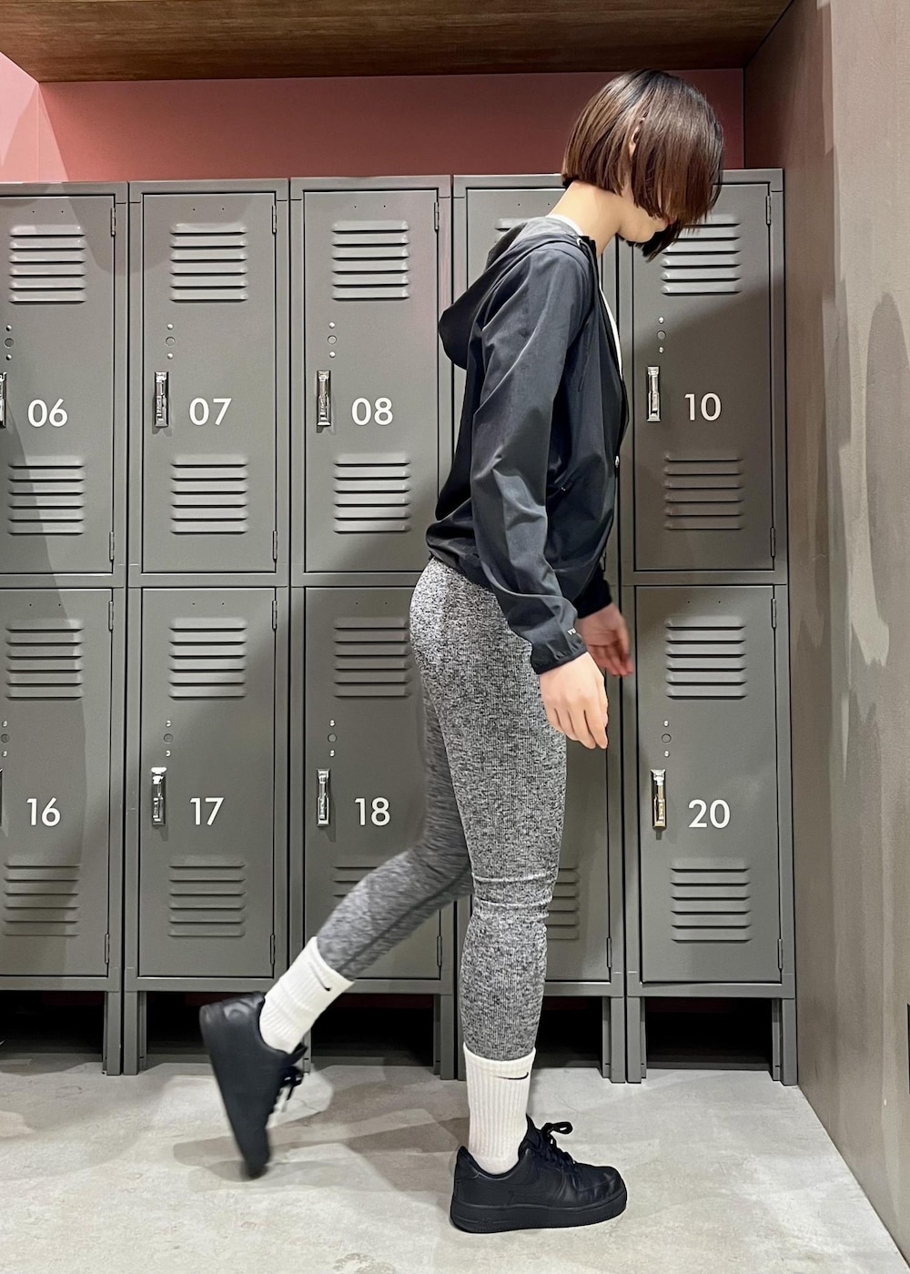 ブラック系のスニーカー、ブラック系のマウンテンパーカー、ホワイト系のTシャツ/カットソーを着用したレディースの春コーディネートの3枚目の写真