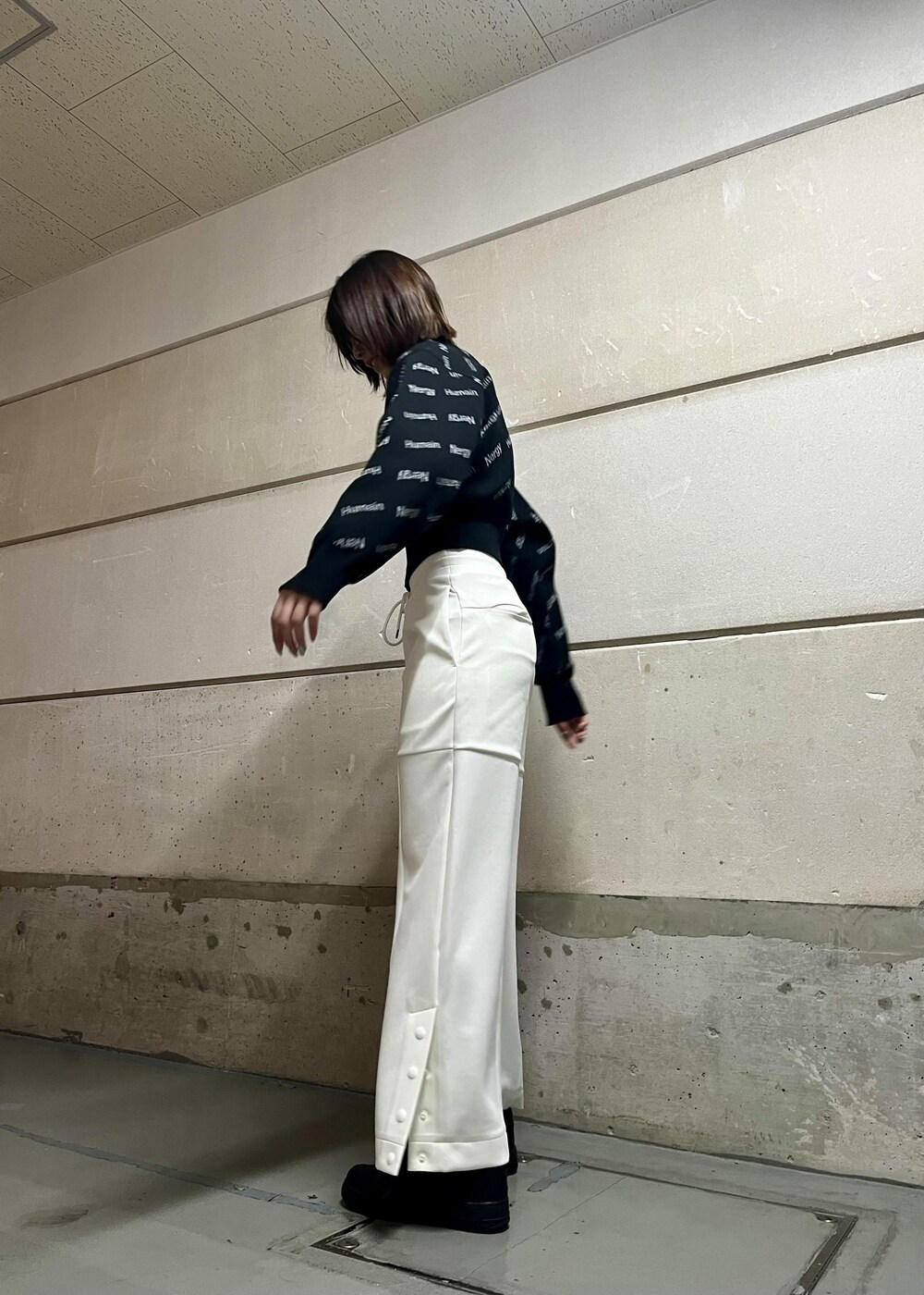 ブラック系のスニーカー、ホワイト系のその他パンツ、ブラック系のその他アウターを着用したレディースの冬コーディネートの2枚目の写真