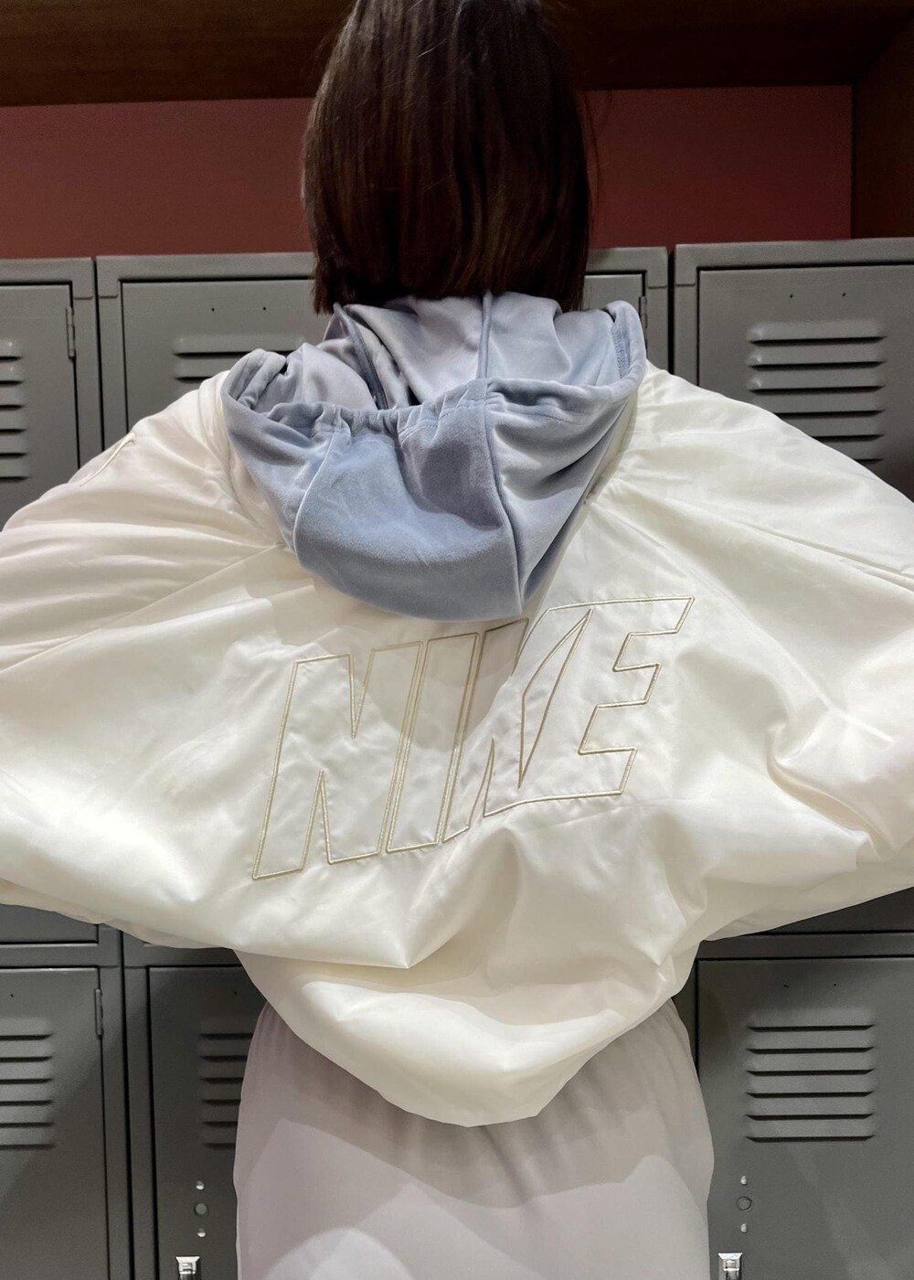 ホワイト系のスニーカー、ブルー系のパーカー、グレー系のスカートを着用したレディースの冬コーディネートの4枚目の写真