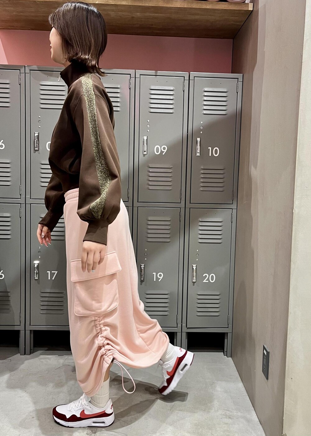 ピンク系のスカート、ブラウン系のその他アウター、ホワイト系のスニーカーを着用したレディースの冬コーディネートの2枚目の写真