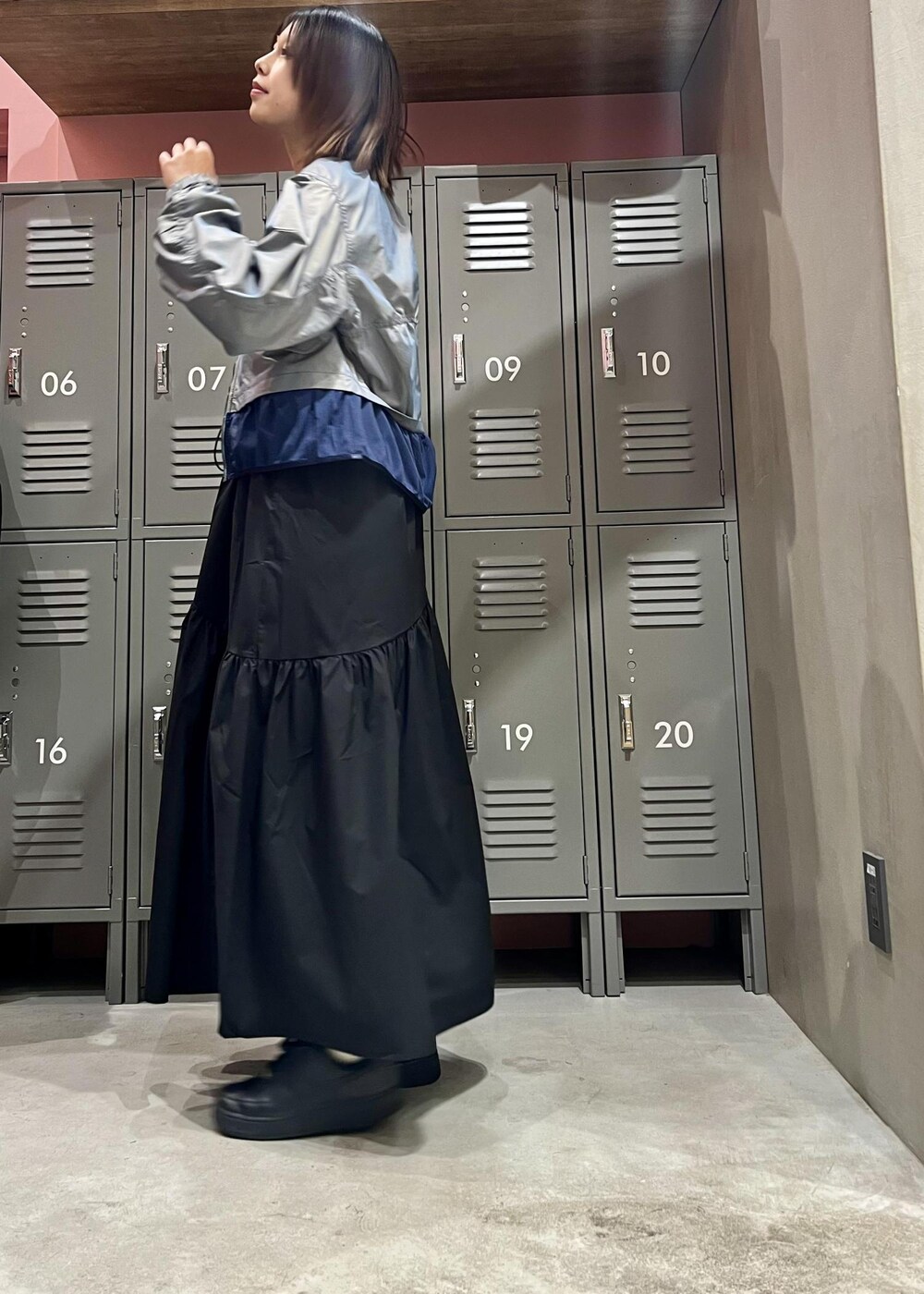 ブラック系のスニーカー、ブラック系のワンピース、ブルー系のブルゾンを着用したレディースの春コーディネートの2枚目の写真