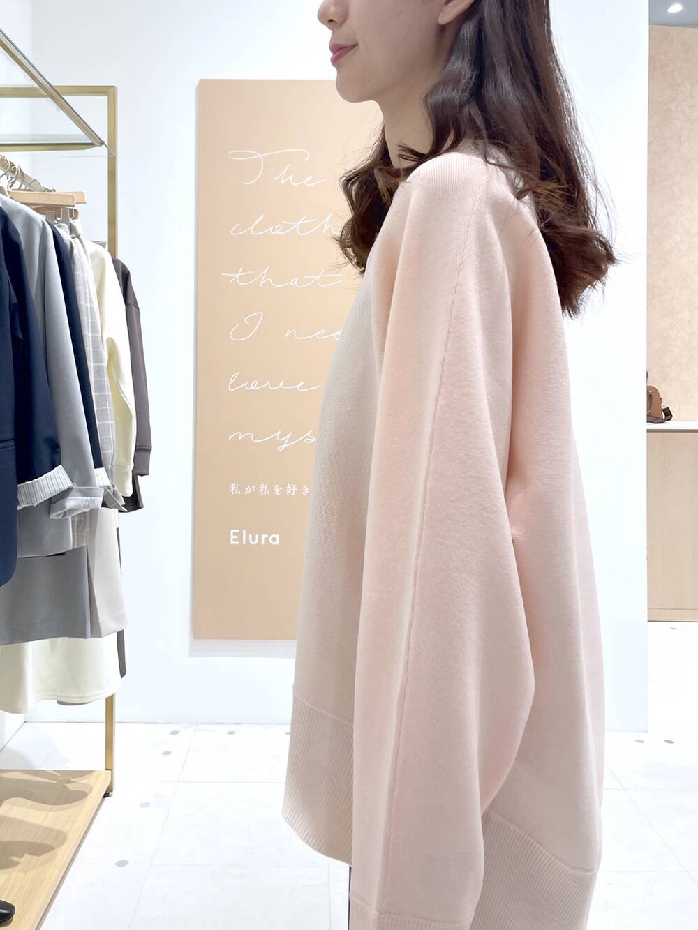 ブラウン系のスカート、ブラック系のハンドバッグ、ピンク系のニット/セーターを着用したレディースの春コーディネートの5枚目の写真