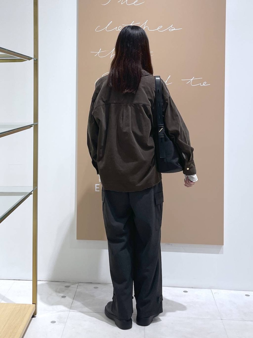 ブラック系のショルダーバッグ、グレー系のシャツ/ブラウス、ホワイト系のTシャツ/カットソーを着用したレディースの秋コーディネートの3枚目の写真