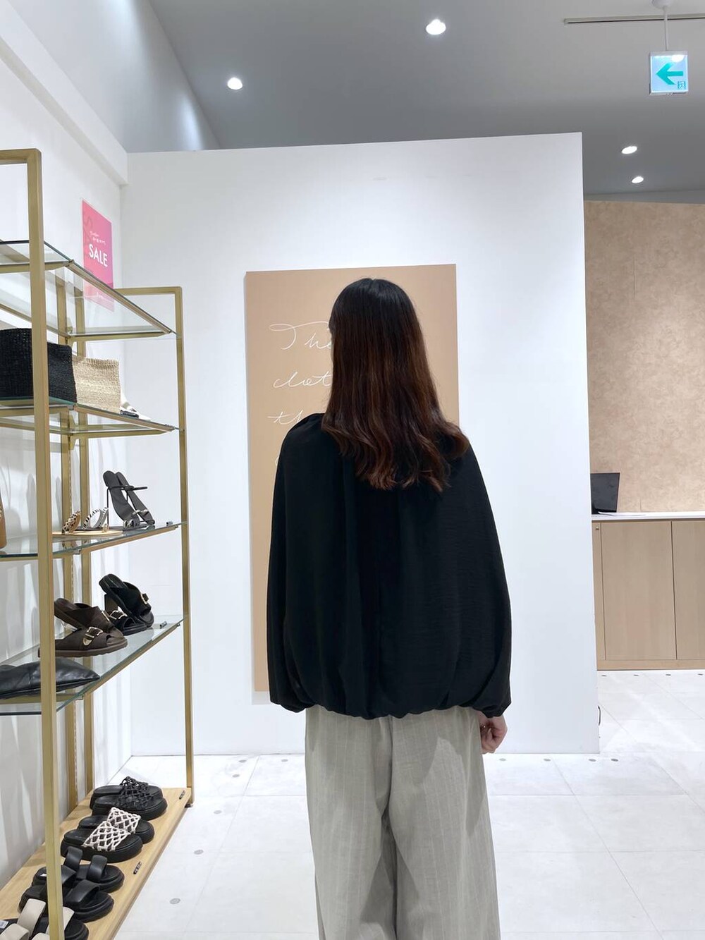 ブラック系のハンドバッグ、ブラック系のサンダル、ベージュ系のその他パンツを着用したレディースの夏コーディネートの6枚目の写真