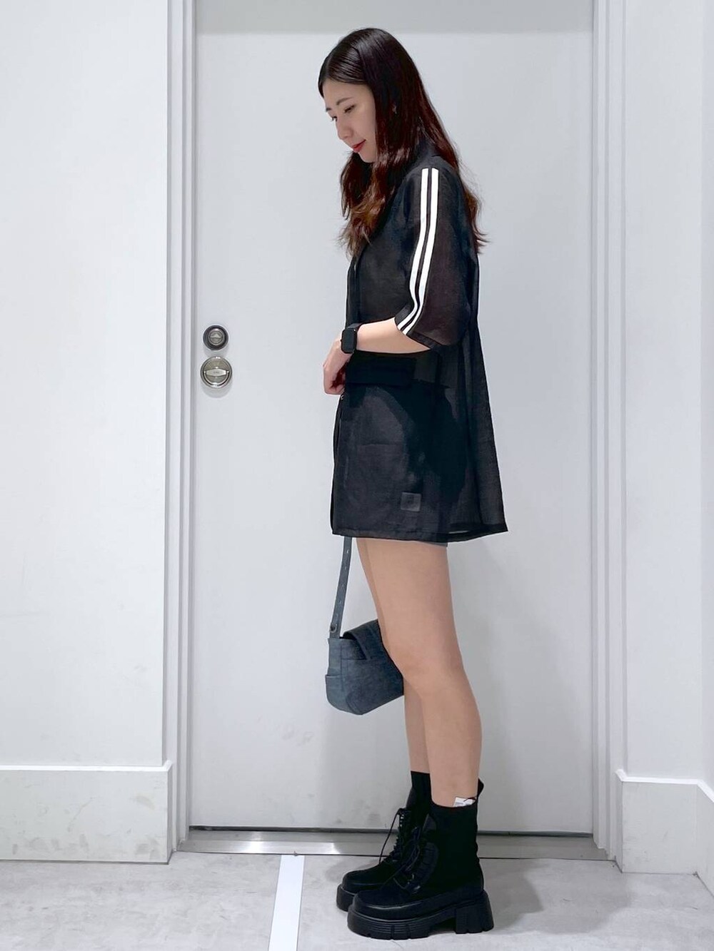 ブラック系のブーツ、ブルー系のショルダーバッグ、グレー系のその他パンツを着用したレディースの春コーディネートの2枚目の写真