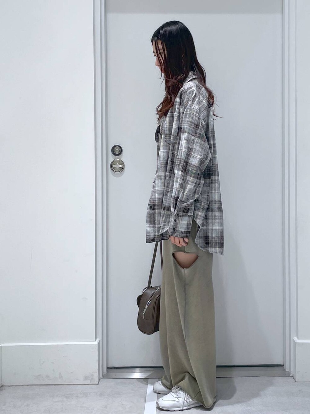 ブラウン系のショルダーバッグ、グレー系のシャツ/ブラウス、グリーン系のスウェットパンツを着用したレディースの冬コーディネートの2枚目の写真