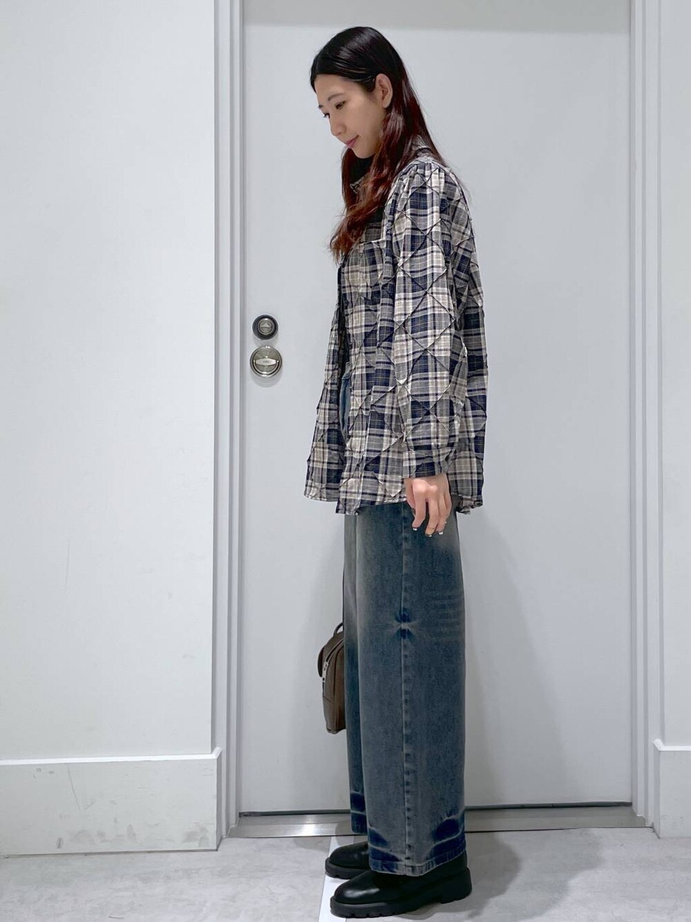 ブラウン系のショルダーバッグ、ブラック系のTシャツ/カットソー、ブルー系のデニムパンツを着用したレディースの春コーディネートの2枚目の写真