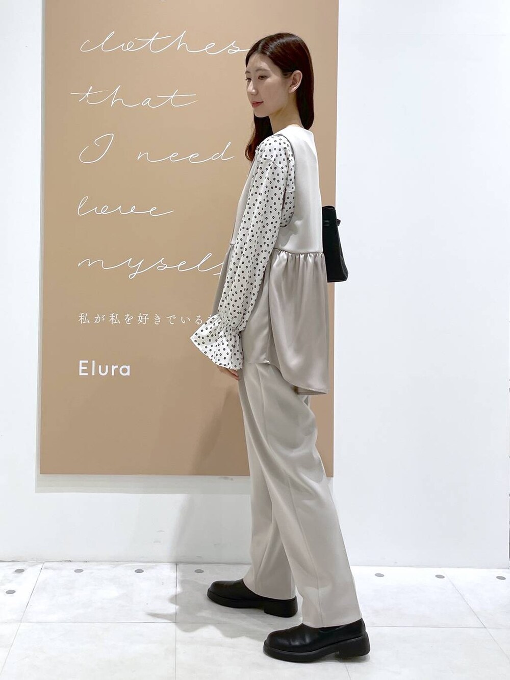 ベージュ系のその他パンツ、ベージュ系のその他アウター、ブラック系のハンドバッグを着用したレディースの冬コーディネートの2枚目の写真