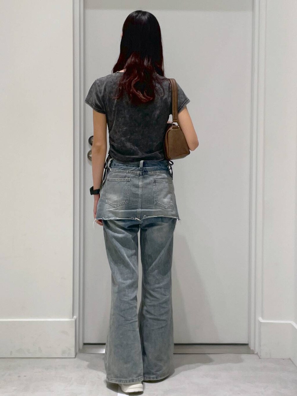 ブラック系のTシャツ/カットソー、ブルー系のデニムパンツ、ブラウン系のハンドバッグを着用したレディースの夏コーディネートの3枚目の写真