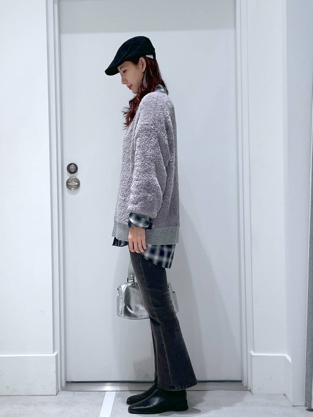 ブラック系のデニムパンツ、シルバー系のショルダーバッグ、ブラック系のシャツ/ブラウスを着用したレディースの冬コーディネートの2枚目の写真