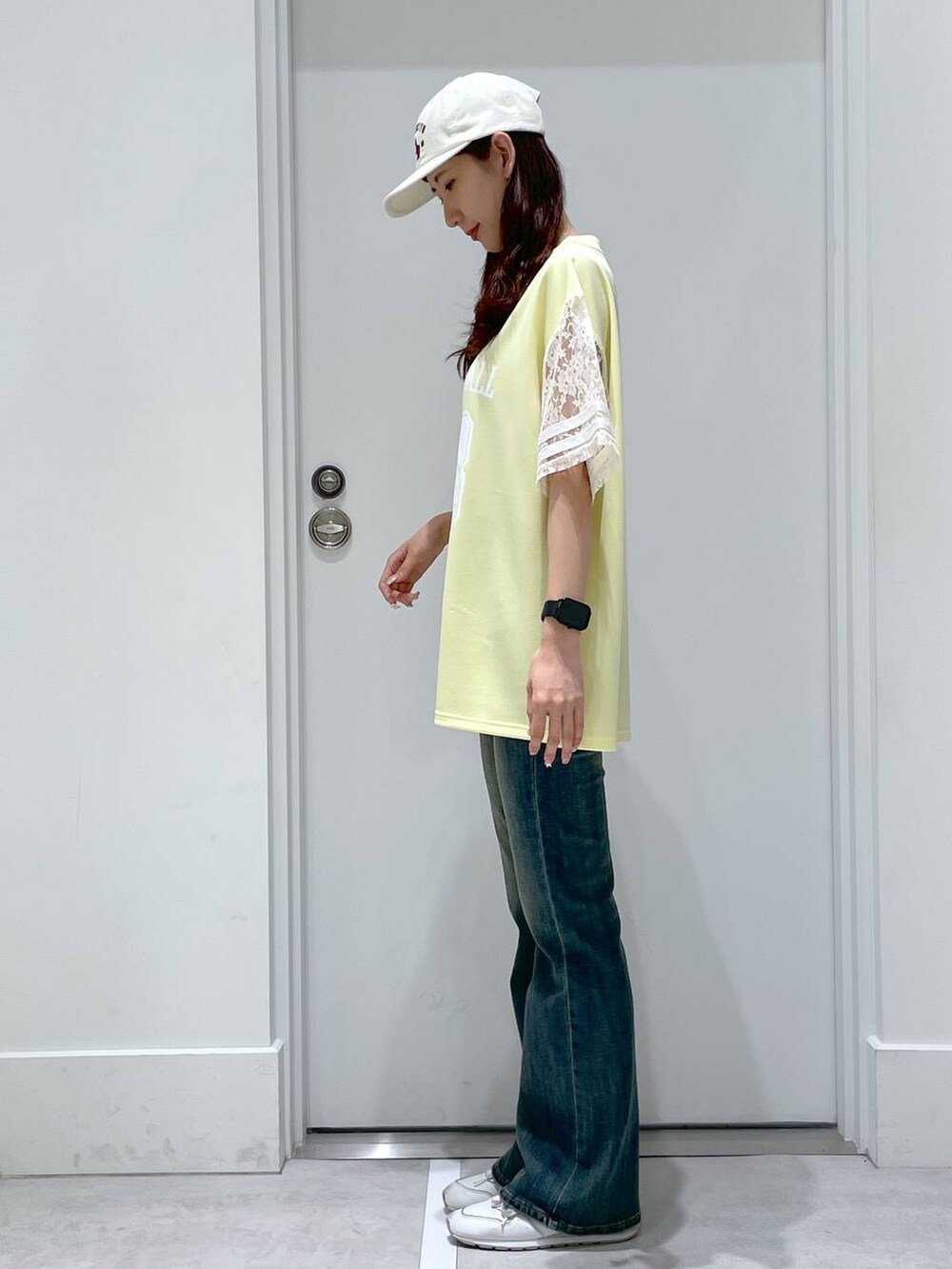 ブルー系のデニムパンツ、ブルー系のボストンバッグ、イエロー系のTシャツ/カットソーを着用したレディースの春コーディネートの2枚目の写真