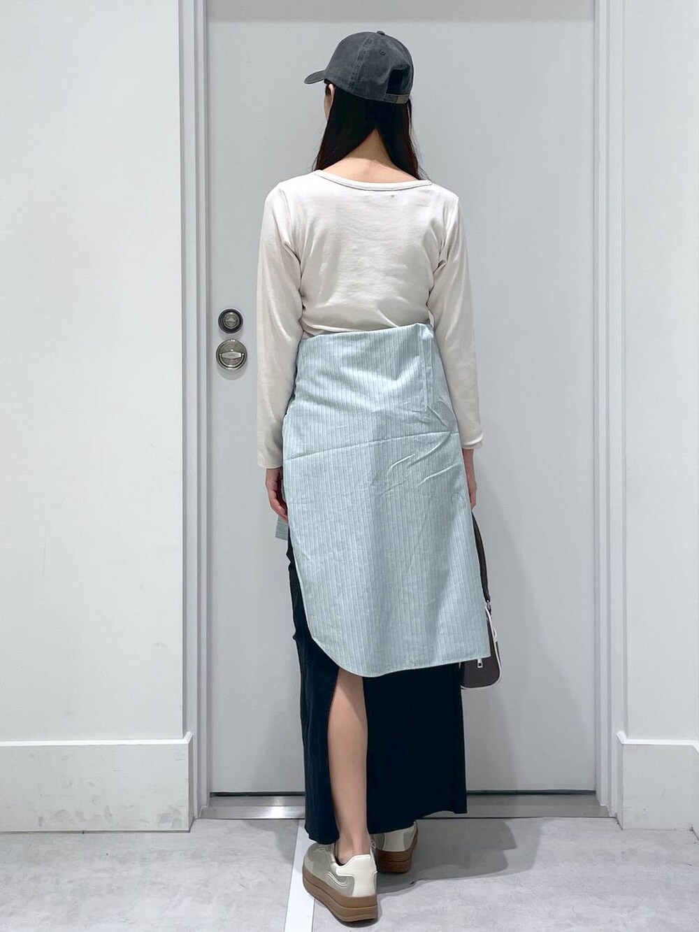 グリーン系のシャツ/ブラウス、ブラック系のスカート、ホワイト系のTシャツ/カットソーを着用したレディースの春コーディネートの3枚目の写真