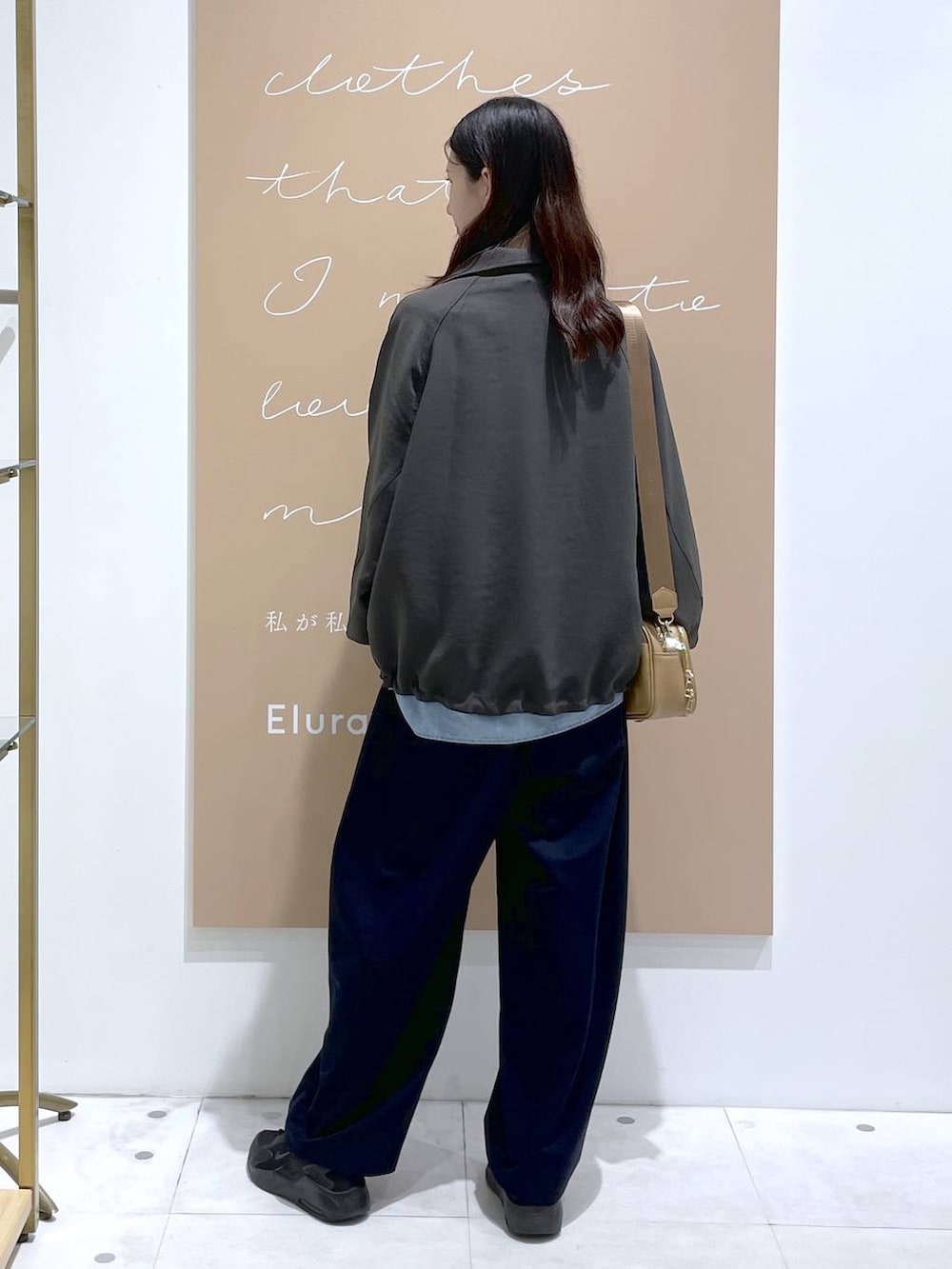 グレー系のブルゾン、ブルー系のその他パンツ、イエロー系のショルダーバッグを着用したレディースの秋コーディネートの3枚目の写真