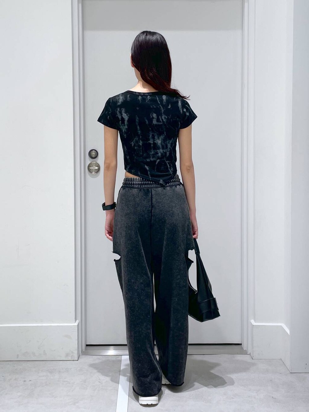 ブラック系のスウェットパンツ、ブラック系のショルダーバッグ、ブラック系のTシャツ/カットソーを着用したレディースの夏コーディネートの3枚目の写真