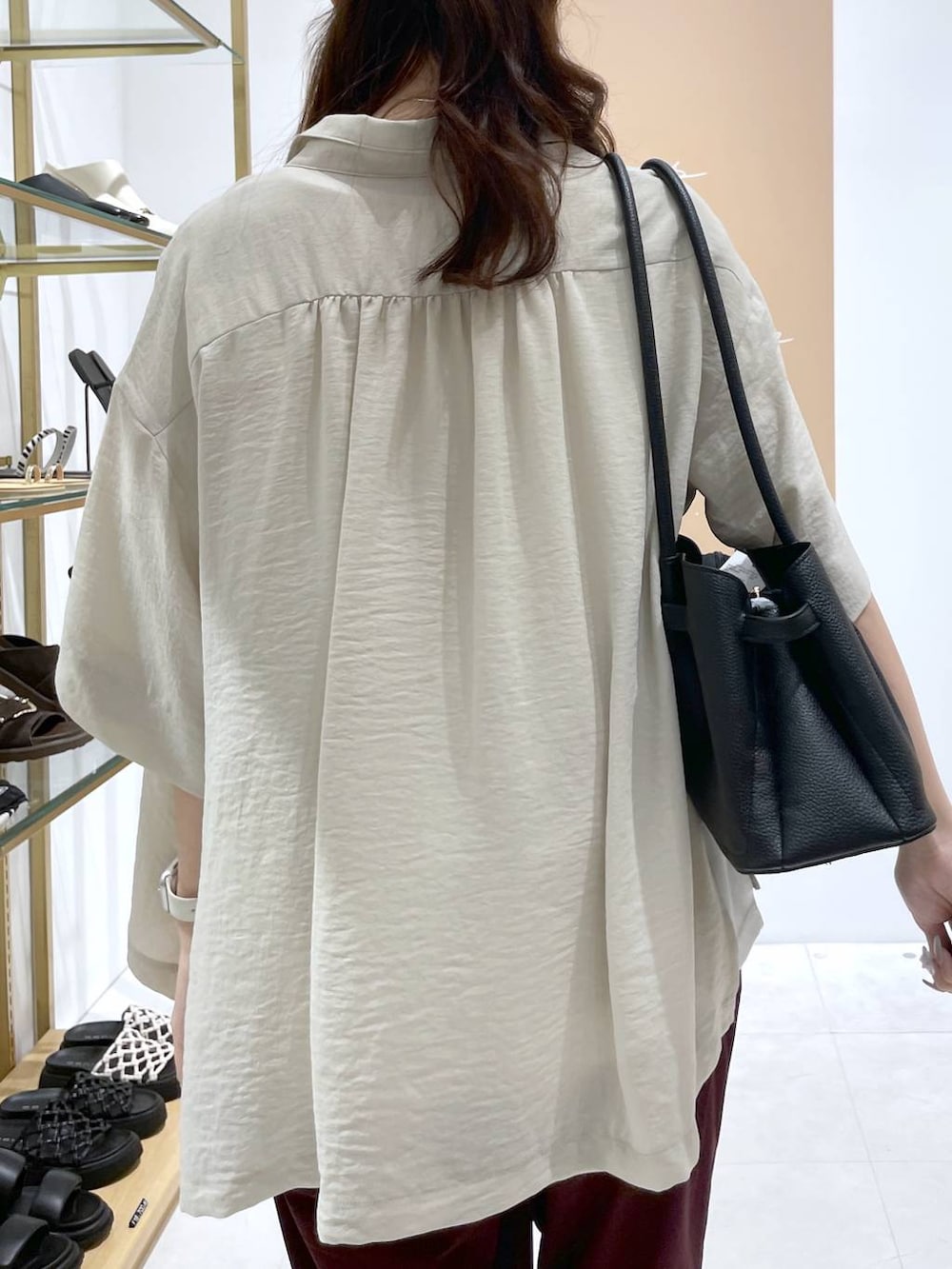 ブラック系のハンドバッグ、ブラック系のサンダル、ホワイト系のTシャツ/カットソーを着用したレディースの夏コーディネートの4枚目の写真