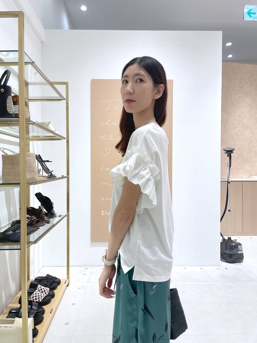 グリーン系のその他パンツ、ブラック系のトートバッグ、ホワイト系のTシャツ/カットソーを着用したレディースの夏コーディネートの5枚目の写真