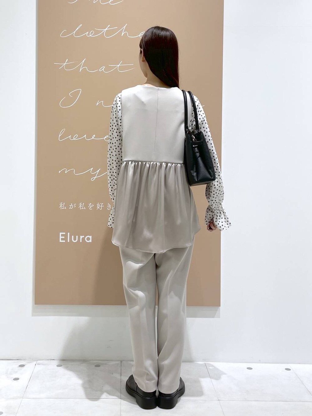 ベージュ系のその他パンツ、ベージュ系のその他アウター、ブラック系のハンドバッグを着用したレディースの冬コーディネートの3枚目の写真