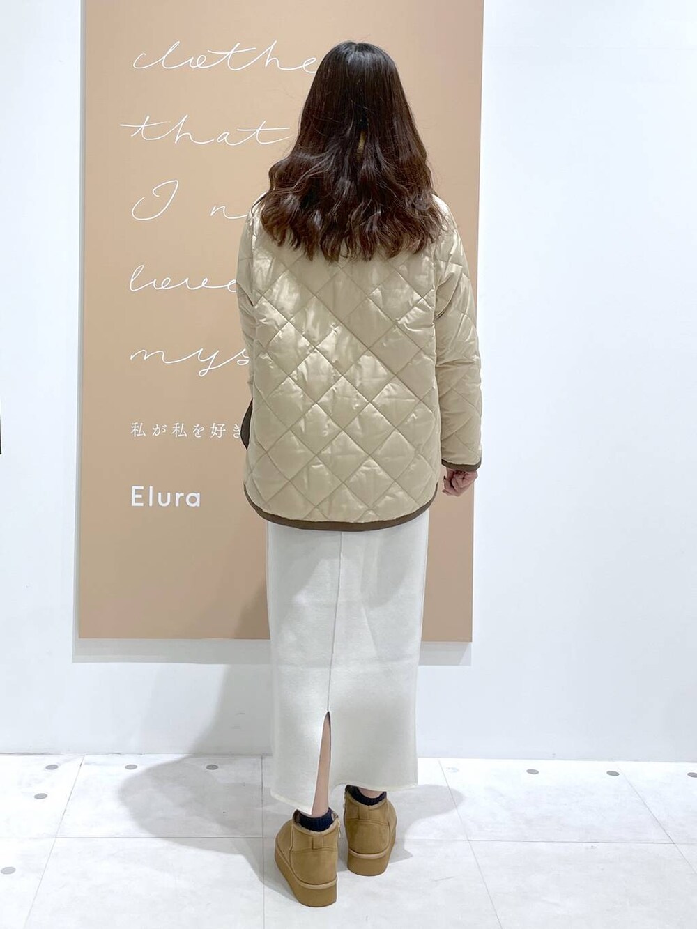 ブラウン系のブーツ、ベージュ系のダウンジャケット/コート、ブラック系のショルダーバッグを着用したレディースの冬コーディネートの3枚目の写真