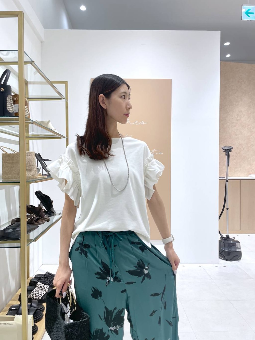 グリーン系のその他パンツ、ブラック系のトートバッグ、ホワイト系のTシャツ/カットソーを着用したレディースの夏コーディネートの4枚目の写真