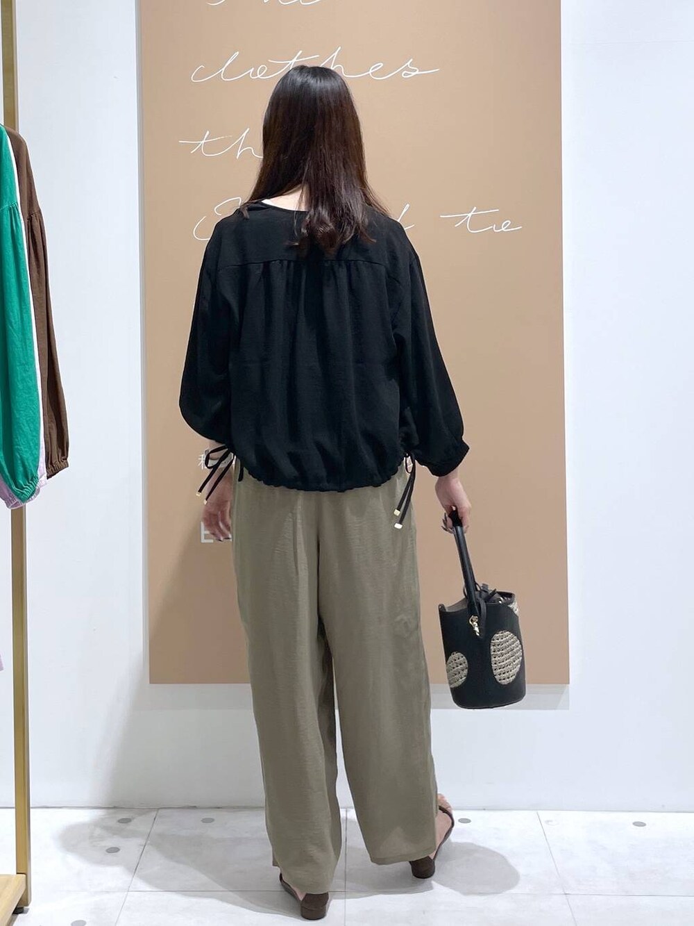 ホワイト系のその他パンツ、ホワイト系のタンクトップ、ブラック系のハンドバッグを着用したレディースの夏コーディネートの3枚目の写真