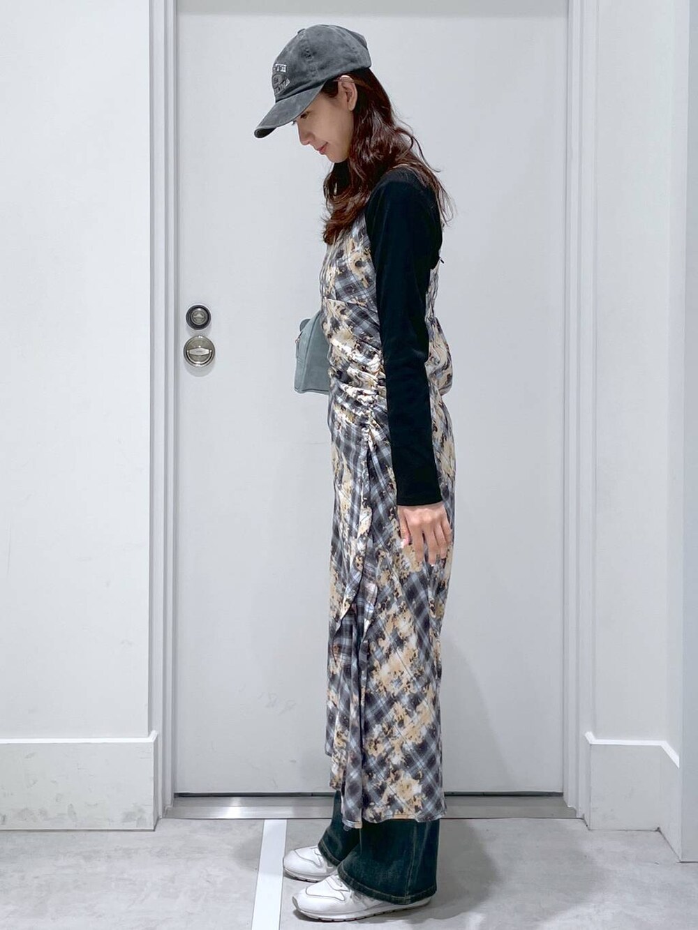 ブルー系のデニムパンツ、ブルー系のショルダーバッグ、ブルー系のワンピースを着用したレディースの春コーディネートの2枚目の写真