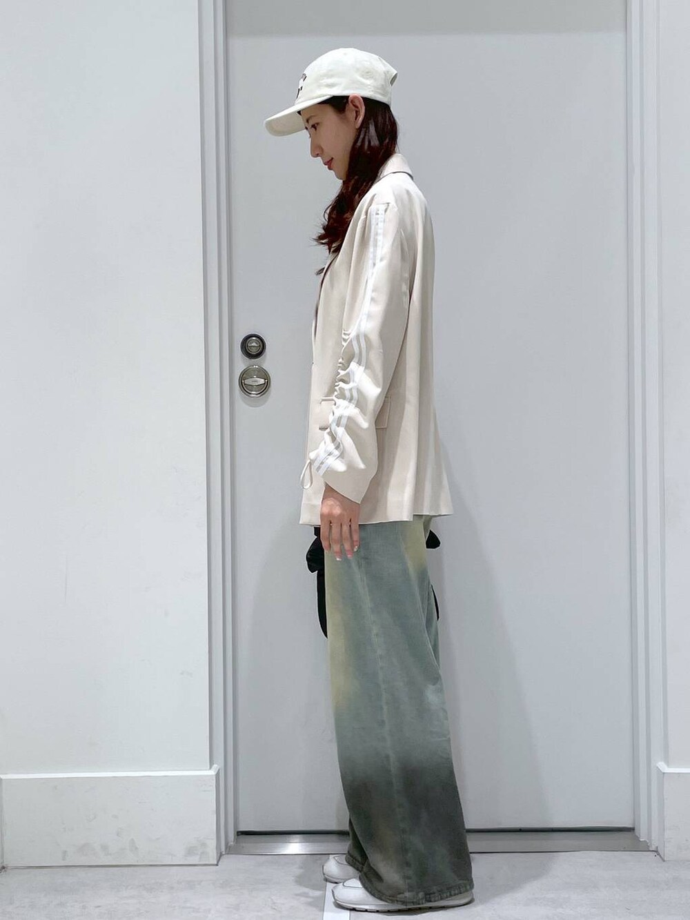 ホワイト系のTシャツ/カットソー、ブラック系のハンドバッグ、ベージュ系のテーラードジャケットを着用したレディースの春コーディネートの2枚目の写真