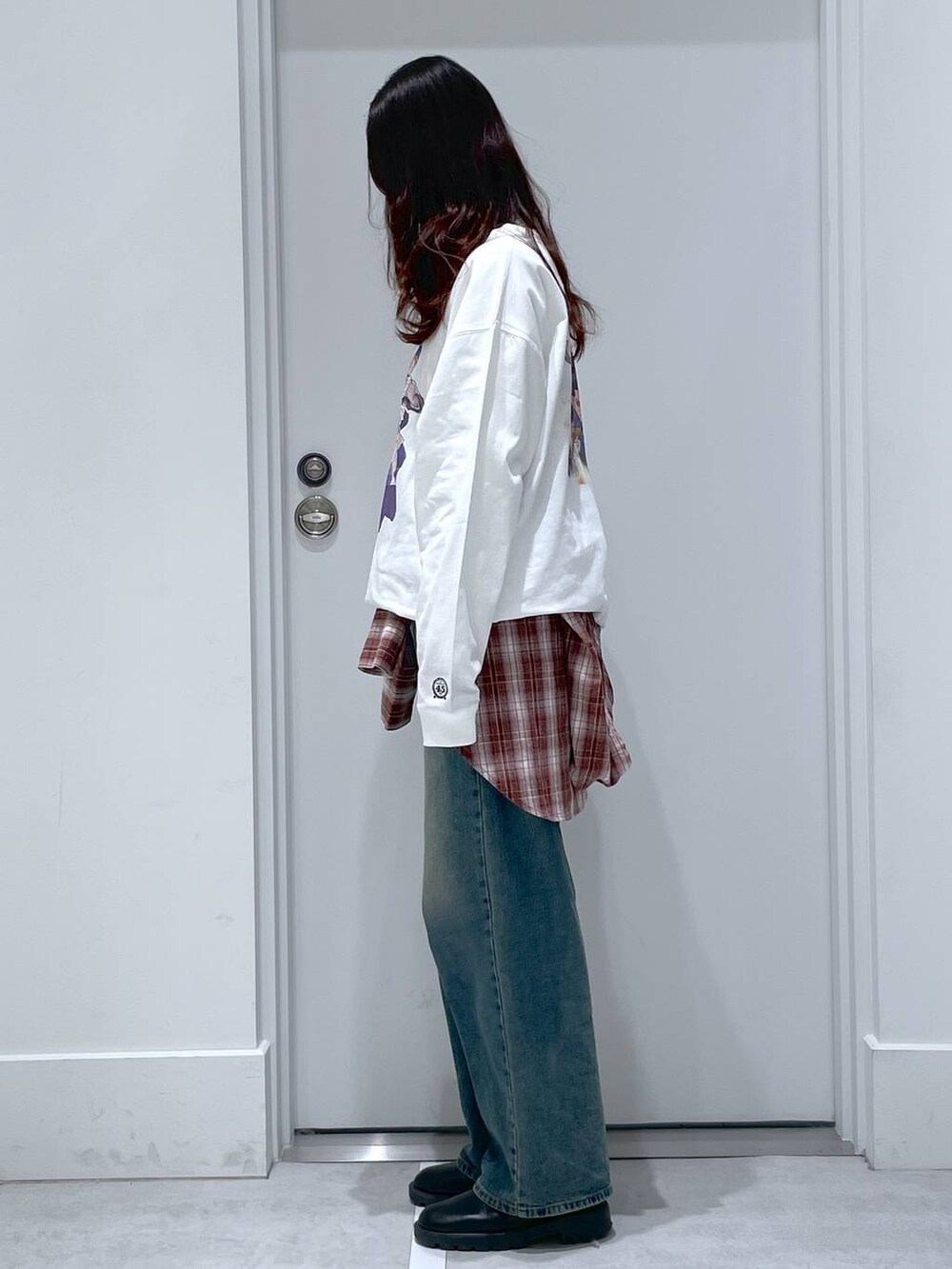 ブルー系のデニムパンツ、レッド系のシャツ/ブラウス、ホワイト系のTシャツ/カットソーを着用したレディースの冬コーディネートの2枚目の写真