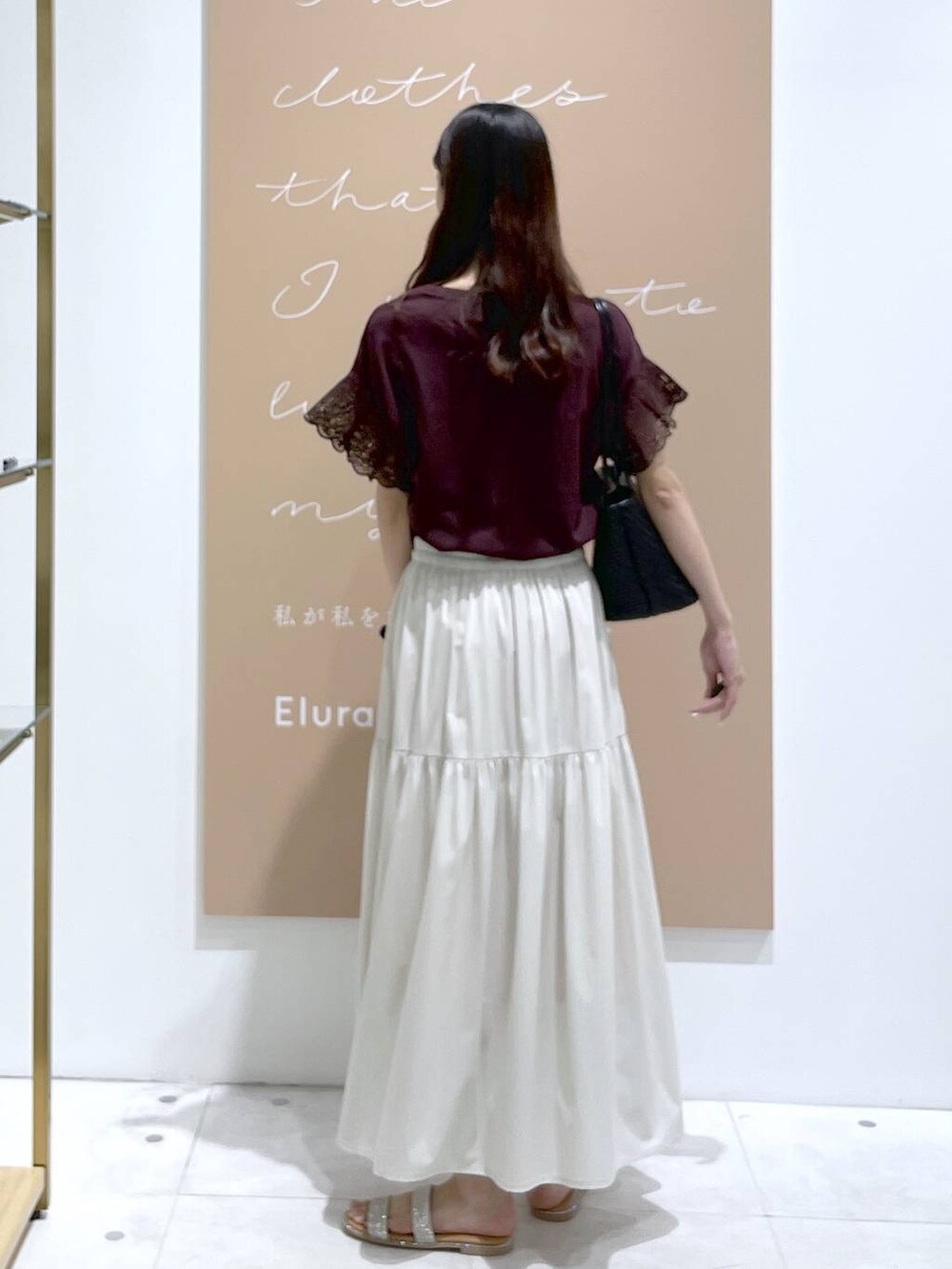 レッド系のTシャツ/カットソー、シルバー系のサンダル、ホワイト系のスカートを着用したレディースの夏コーディネートの3枚目の写真