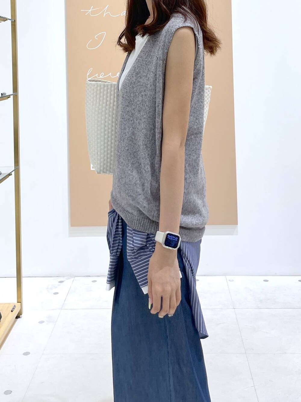 ブルー系のデニムパンツ、ブルー系のシャツ/ブラウス、ホワイト系のかごバッグを着用したレディースの夏コーディネートの5枚目の写真